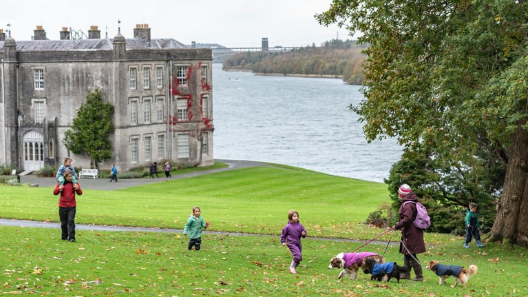Family walking along the lawn in Autumn at Plas Newydd